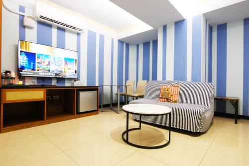 a waiting room with a chair and a television at I Hi Loveriver Hotel in Kaohsiung