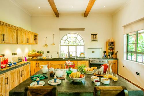 een keuken met een tafel met fruitschalen erop bij Treetops Villa in Arusha