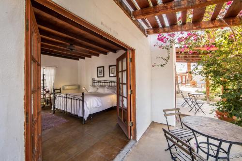 a bedroom with a bed and a table and chairs at Korakia Pensione in Palm Springs