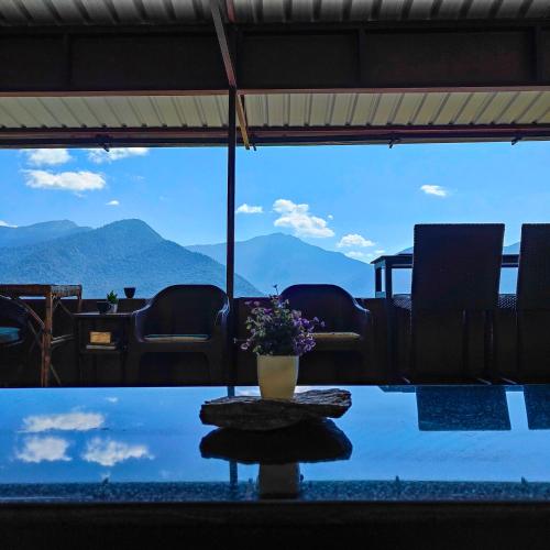 a table with a pot of flowers on top of a pool at Cafe Buransh in Sari