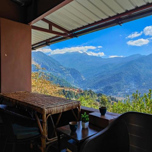a balcony with a table and a view of mountains at Cafe Buransh in Sari