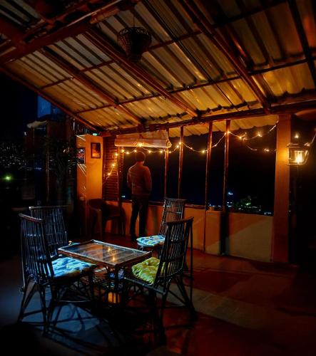 a man standing on a patio with a table and chairs at Cafe Buransh in Sari