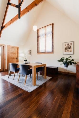 a dining room with a wooden table and chairs at Homestead Loft retreat Heated Pool, Spa, Basketball court, Spa bath in loft in Wallington