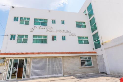 a white building with the words j suites pueblo at Suites Poliforum Inn in León