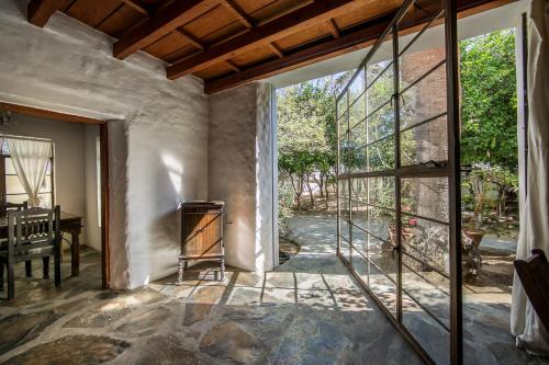 an open living room with a fireplace and a glass door at Korakia Pensione in Palm Springs