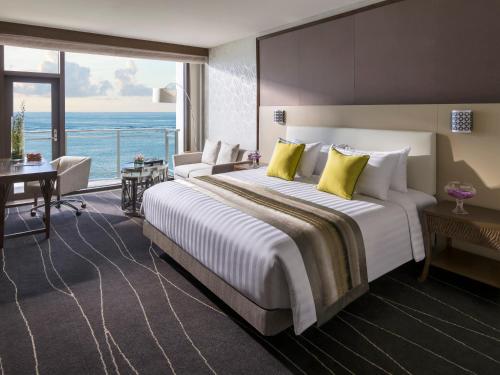 a hotel room with a large bed and a large window at Dusit Thani Guam Resort in Tumon