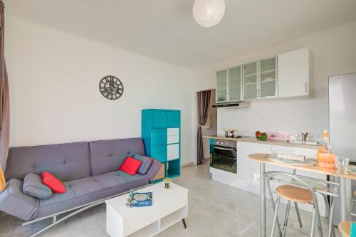 Il comprend un salon avec un canapé violet et une cuisine. dans l'établissement Appartement Fabrina - Happy Rentals, à Nice