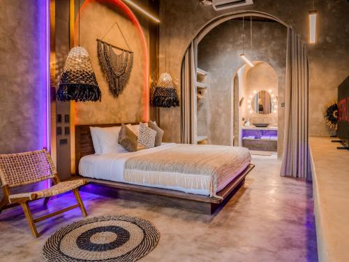 a bedroom with a bed and a chair at Diwatu Villas in El Nido