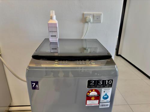 a bottle of soap sitting on top of a machine at Cozy Urban Suites Georgetown View in Jelutong