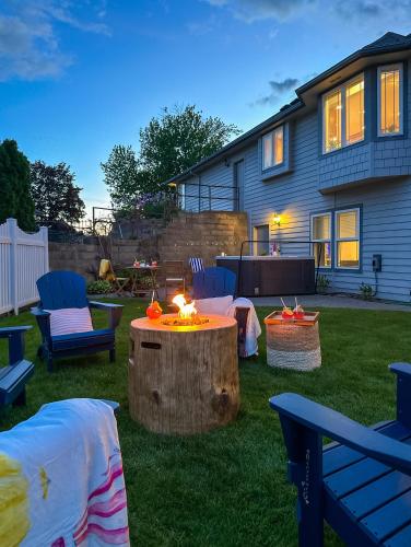 a backyard with a fire table and chairs and a house at Soaring Spirit - Hot Tub, Pool Table, Arcades, 2 kitchens in Walla Walla