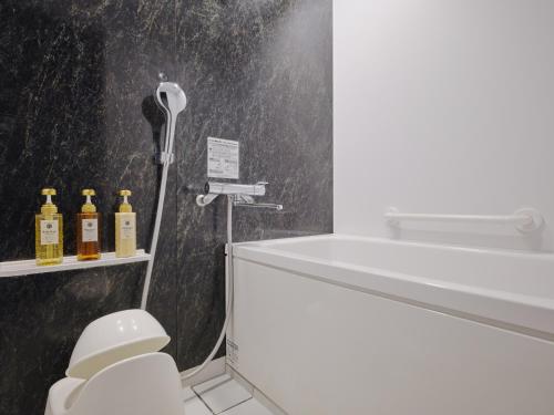 a bathroom with a white toilet and a sink at hotel MONday Asakusa in Tokyo