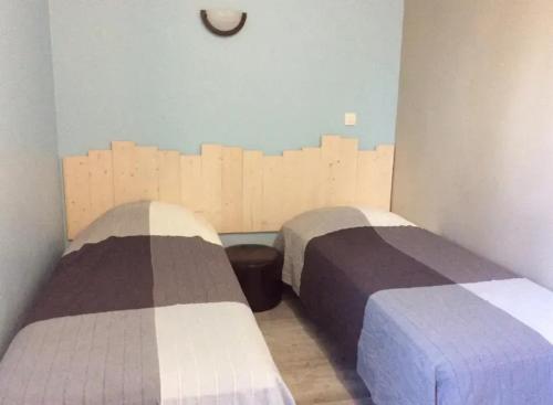 two beds in a room with wooden walls at Villa spacieuse avec piscine à Saint-Sauveur-en-Rue in Saint-Sauveur-en-Rue