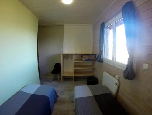 a small bedroom with two beds and a window at Villa spacieuse avec piscine à Saint-Sauveur-en-Rue in Saint-Sauveur-en-Rue