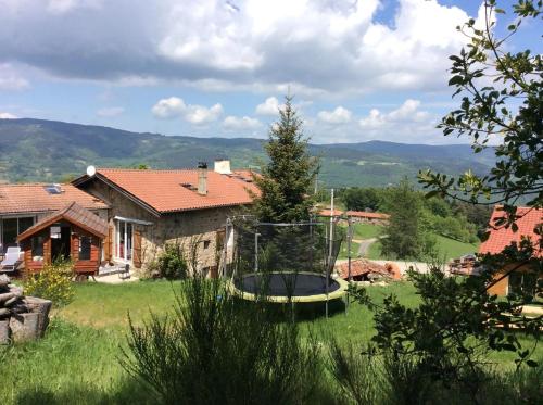 a view of a house with a trampoline in a yard at Villa spacieuse avec piscine à Saint-Sauveur-en-Rue in Saint-Sauveur-en-Rue