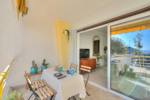 Cette chambre dispose d'une table, de chaises et d'un balcon. dans l'établissement Marco Polo Port View - Happy Rentals, au Golfe-Juan