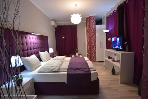 a bedroom with a large bed with a purple headboard at Villa Radica in Negotino