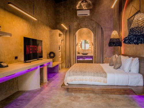 a bedroom with a king sized bed and a tv at Diwatu Villas in El Nido