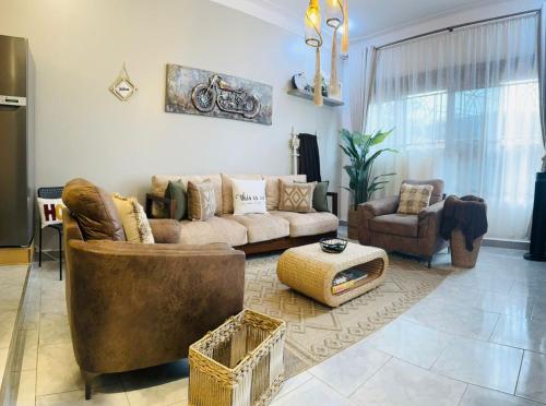 a living room with a couch and chairs and a table at Gamaleo Apartment Namulanda in Namulanda