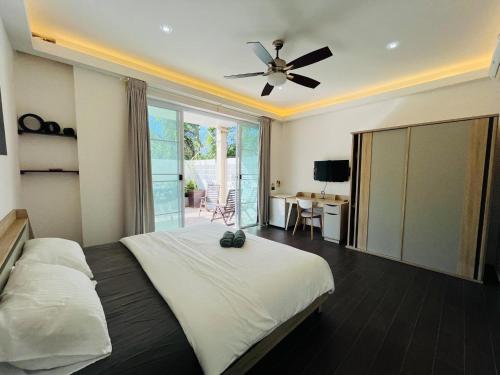 a bedroom with a bed and a ceiling fan at POOL VILLA TIPPAWAN Koh Chang in Ko Chang