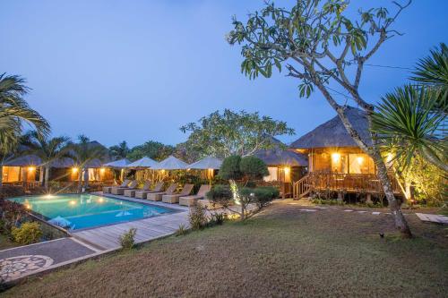 a villa with a swimming pool and a resort at Lembongan Mantra Huts in Nusa Lembongan