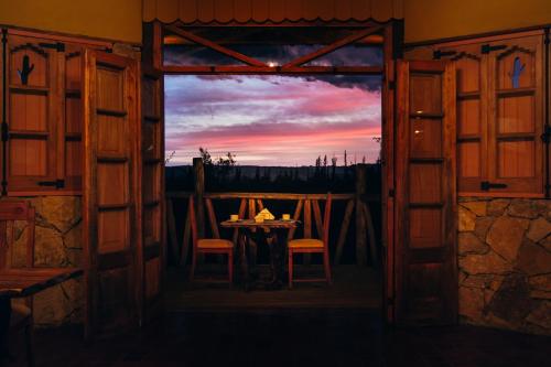 an open door of a room with a table and a sunset at Finca La Encantada in San Rafael
