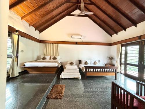 a room with two beds and a couch in it at Unlock By Goldfinch Sakaleshpur in Kenchamman Hoskota