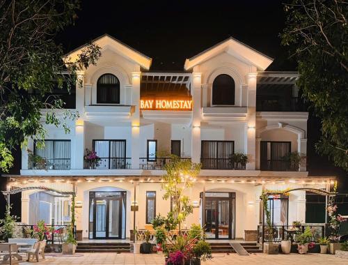 a large white building with a sign on it at Bay Homestay in Cam Lâm