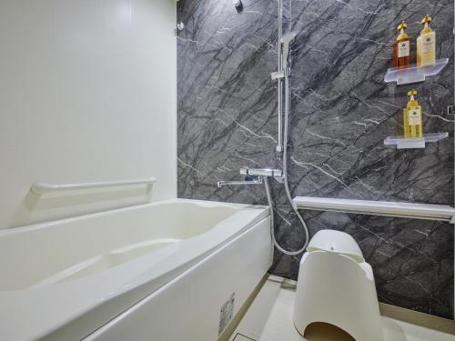 a bathroom with a shower and a white toilet at MONday Apart Nihonbashi Ningyocho in Tokyo