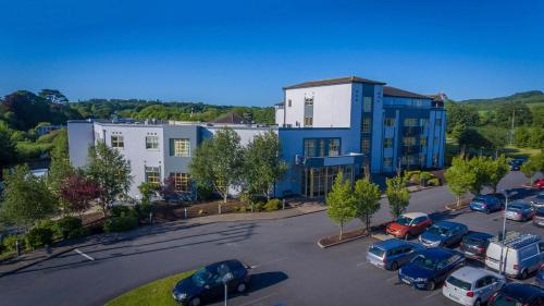 an apartment building with cars parked in a parking lot at Newtown Park Hotel in Wexford