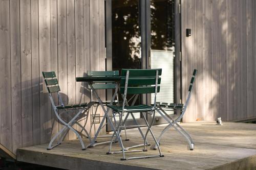 two green chairs and a table on a porch at Tiny House Pioneer 3 - Green Tiny Spot Friesland in Schortens