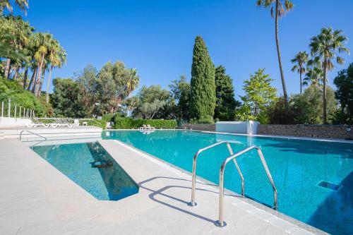 une grande piscine d'eau bleu clair dans l'établissement Studio La Mirandole Sea View - Happy Rentals, au Golfe-Juan
