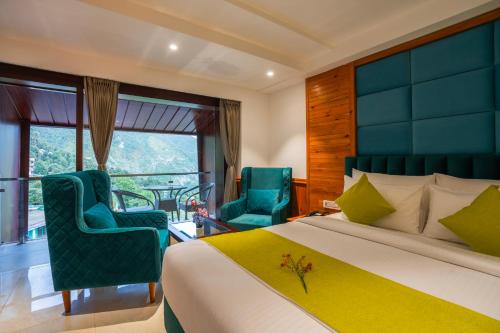a bedroom with a bed and two chairs and a balcony at Alt Life Luxe - Himalayan Crown - Dharamkot Mcleodganj in Dharamshala