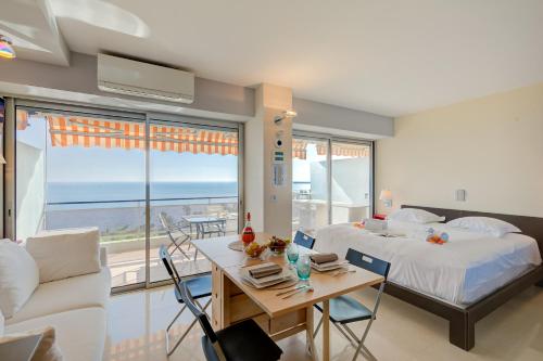- une chambre avec un lit et un bureau avec une table dans l'établissement Studio La Mirandole Sea View - Happy Rentals, au Golfe-Juan