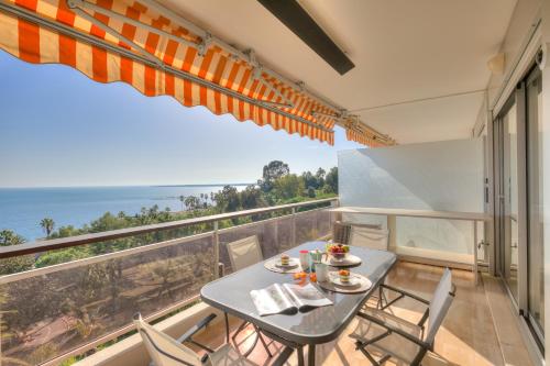 une table et des chaises sur un balcon avec vue sur l'océan dans l'établissement Studio La Mirandole Sea View - Happy Rentals, au Golfe-Juan