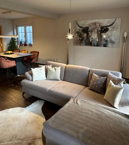 a living room with a couch with a deer picture on the wall at Haus am Mühlbach in Burgkirchen an der Alz