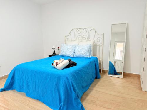 a woman laying on a blue bed in a bedroom at Rosa Rooms, Habitación con baño privado in Pozuelo de Alarcón