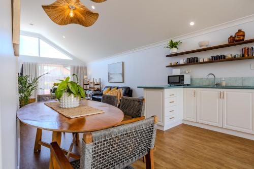 a kitchen and living room with a table and chairs at Albany Bayside by the BnB Collection in Albany