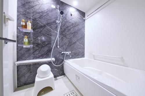 a bathroom with a shower and a white toilet at MONday Apart Premium AKIHABARA in Tokyo