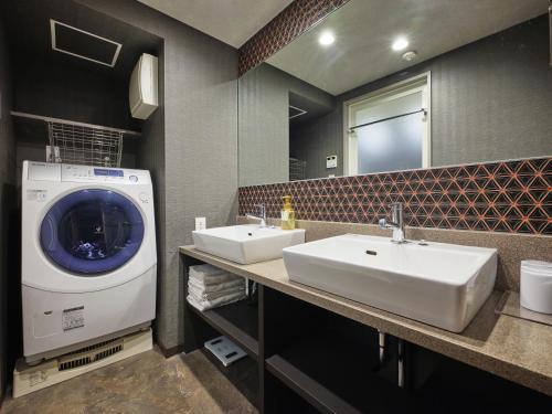 a bathroom with two sinks and a washing machine at MONday Apart Nihonbashi Ningyocho in Tokyo