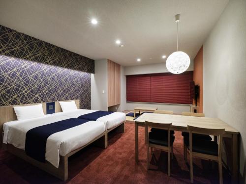 a bedroom with a large bed and a table at MONday Apart Nihonbashi Ningyocho in Tokyo