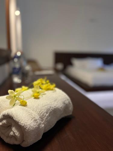 a towel with yellow flowers on top of a counter at Paradise Garden Beruwala in Beruwala
