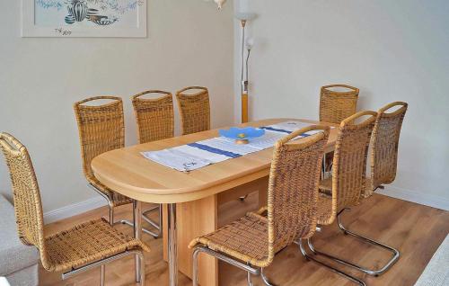 une table à manger avec des chaises en rotin, une table et des chaises dans l'établissement Ferienhaus Zinnowitz Seebad, à Zinnowitz