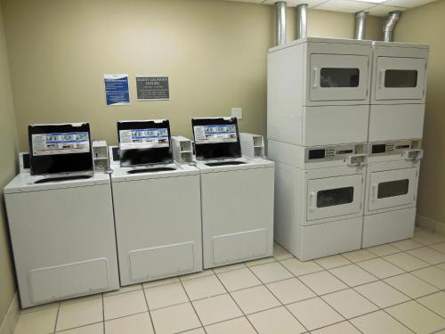 a room with three machines with laptops on them at Baymont by Wyndham Des Moines Airport in Des Moines