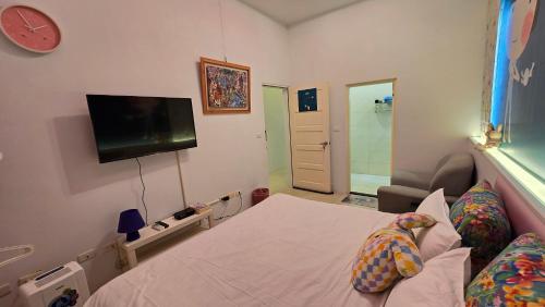 a bedroom with a bed and a tv on the wall at ChaoPingJia Homestay in Luodong