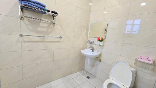 a white bathroom with a toilet and a sink at ChaoPingJia Homestay in Luodong