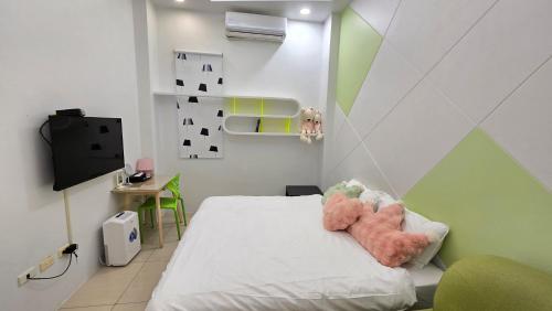 a bedroom with a bed with two stuffed animals on it at ChaoPingJia Homestay in Luodong