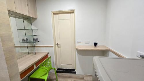 a small kitchen with a green stool in front of a door at ChaoPingJia Homestay in Luodong