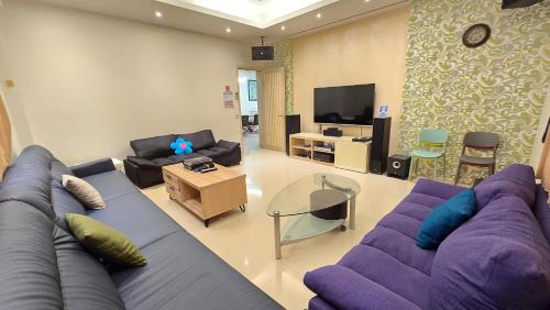 a living room with a purple couch and a tv at ChaoPingJia Homestay in Luodong