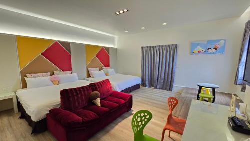 a hotel room with two beds and a red couch at ChaoPingJia Homestay in Luodong