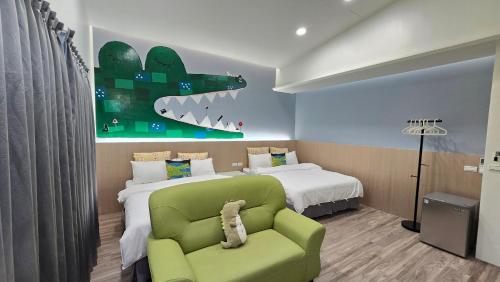 a bedroom with a green chair and a bed at ChaoPingJia Homestay in Luodong